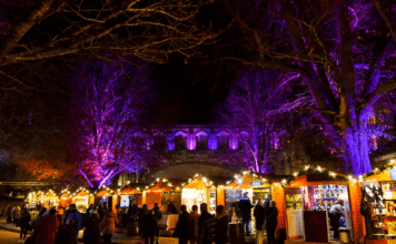 Winchester Christmas Market 2026: Dates, Opening Times & Visitor Guide Wooden chalets at Winchester Christmas Market by the Cathedral.
